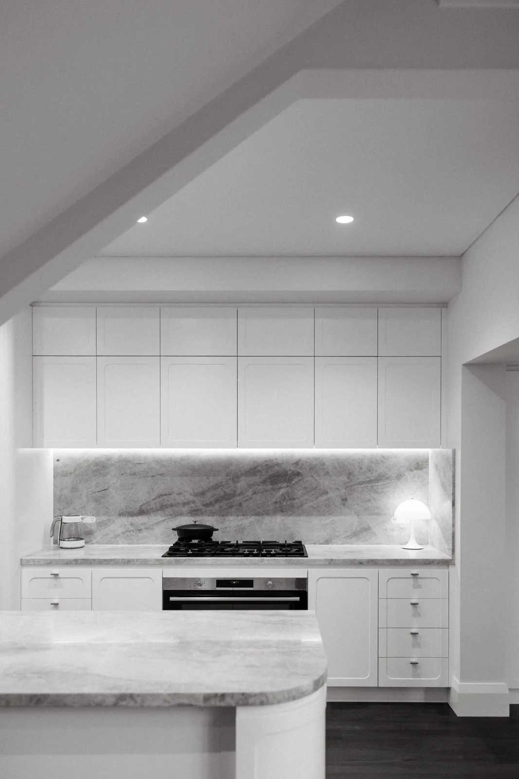 Kitchen with continuous cabinetry and stone splashback