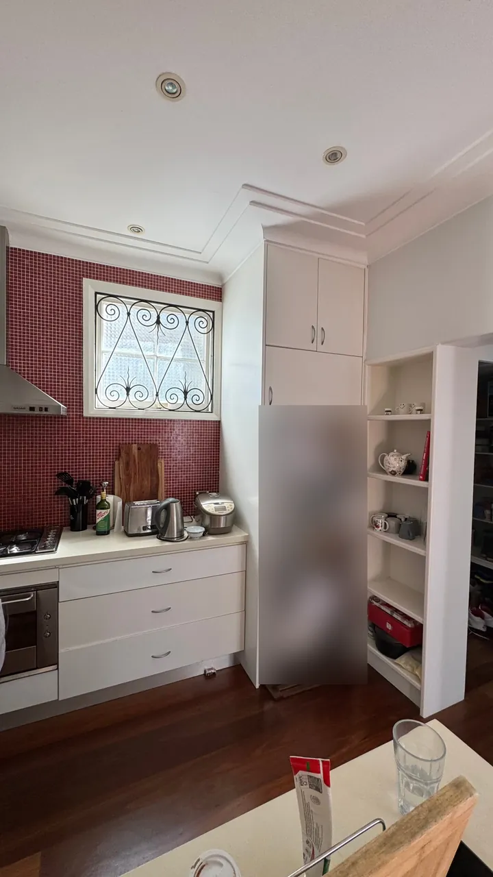 Kitchen window and fridge before renovation